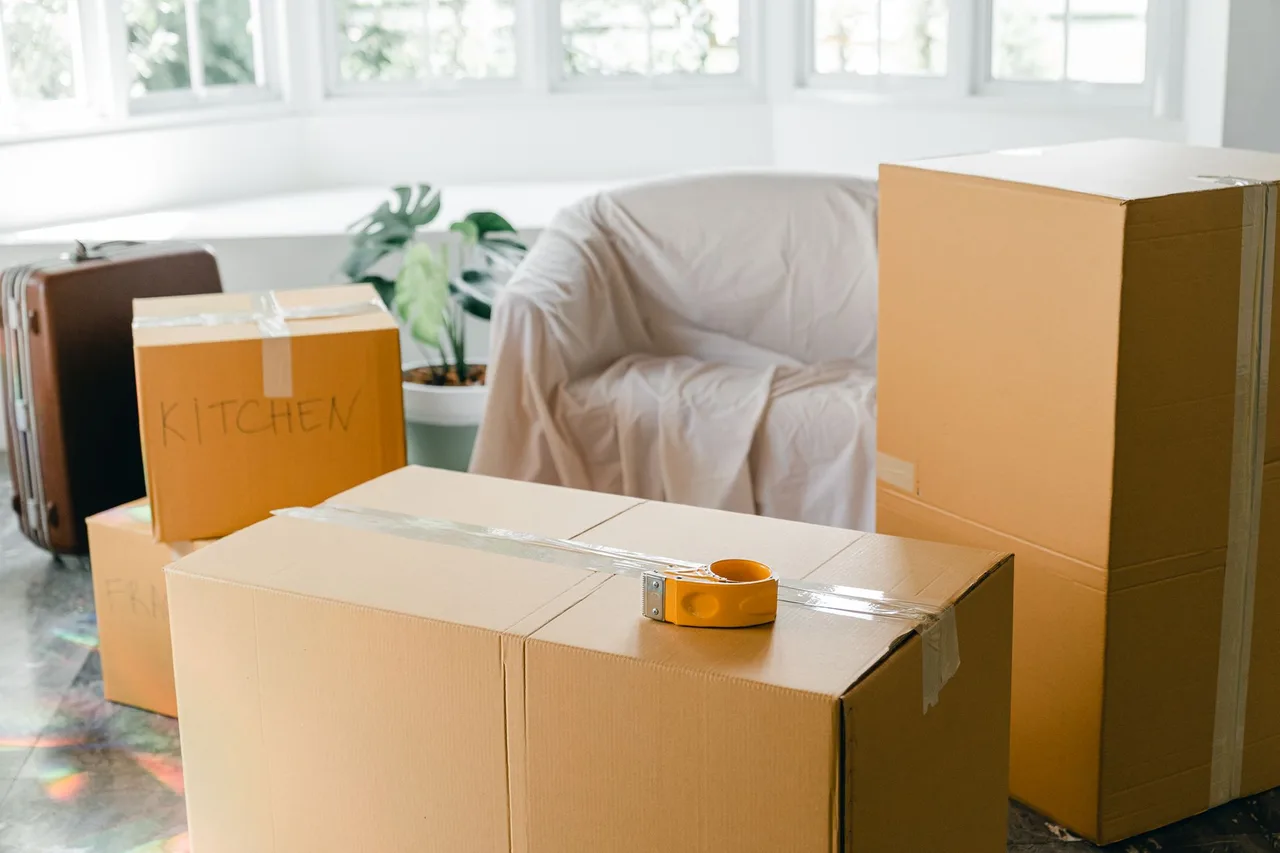 Moving boxes stacked in a bright empty apartment